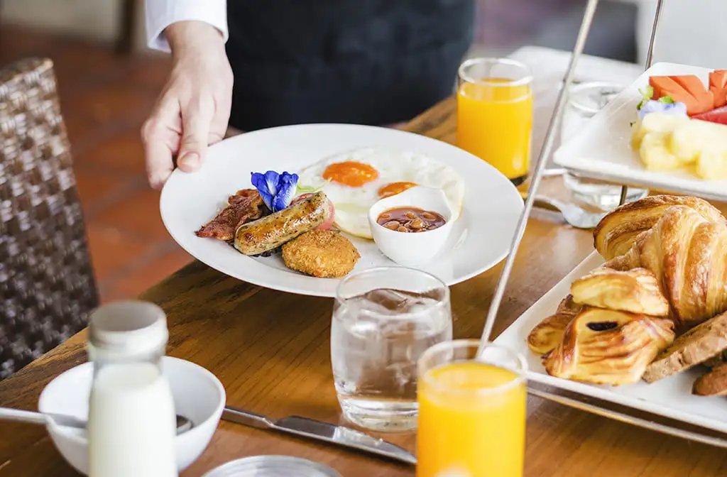 Petit-déjeuner copieux avec jus d'orange et viennoiseries.