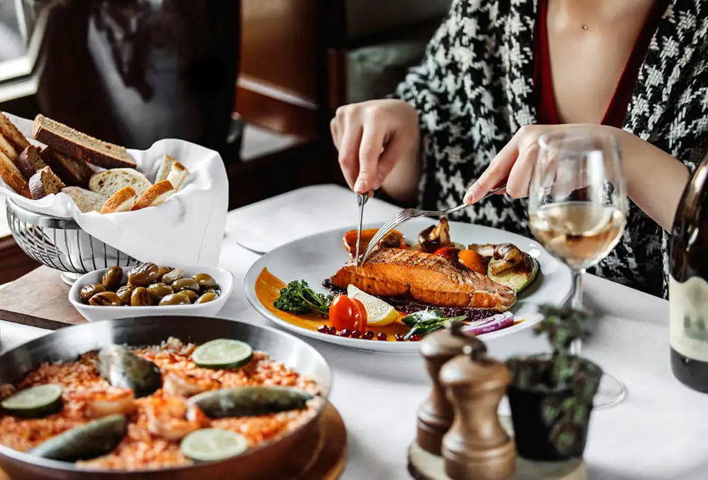 Personne dégustant un plat de saumon au restaurant.
